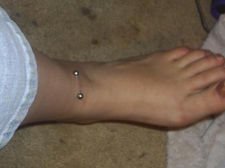 piercings on back dimples. Perfect view of a pierced ankle of a beautiful foot ankle-piercing-1
