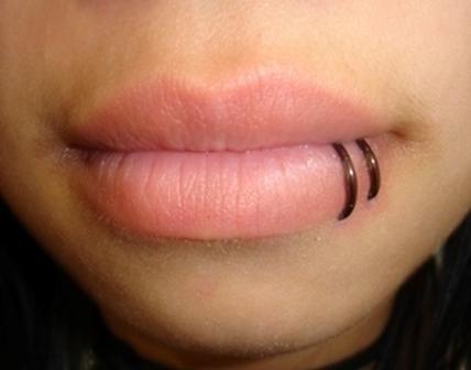 Close up of a ring pierced on lower lips lips-piercing-16