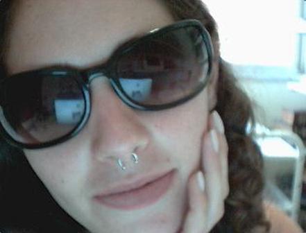 Trendy Girl � Nose Piercing. Young girl in black shades in a pose with her 