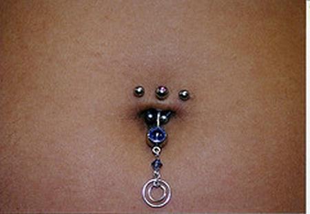Belly Button Ring – Navel Piercing. Extreme close up of an elegant Belly 