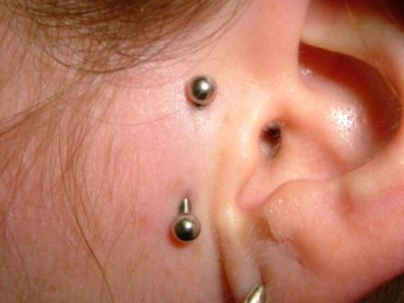 ear piercings pictures. A girl showing her barbell face piercing and ear lobe piercing.