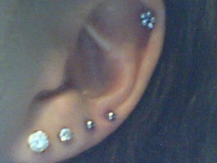 A woman showing earrings in lobe and Helix ear piercing. ear-piercing-24