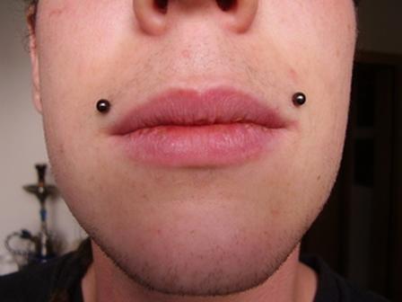 A guy giving close loo of his angelbites lip piercing.
