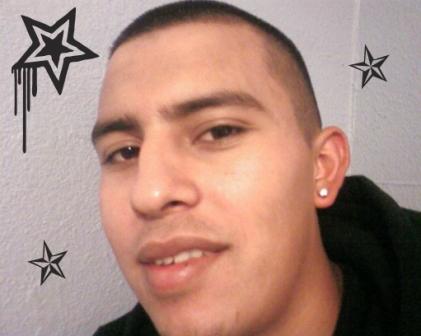 A guy with short hair cut showing his diamond earring pierced in ear lobe.