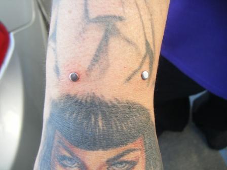 Close look of a tattoo and surface piercing. Devil Tattoo And Wrist Piercing
