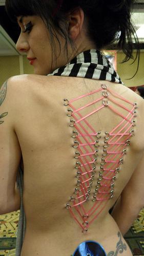 Sexy Model Showing Her Corset Back Piercing