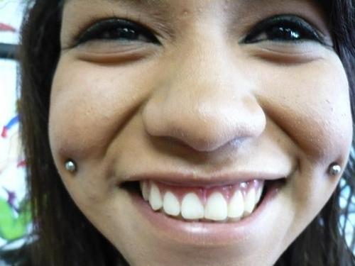 Smiling Girl Showing her Beautiful Cheek Piercing