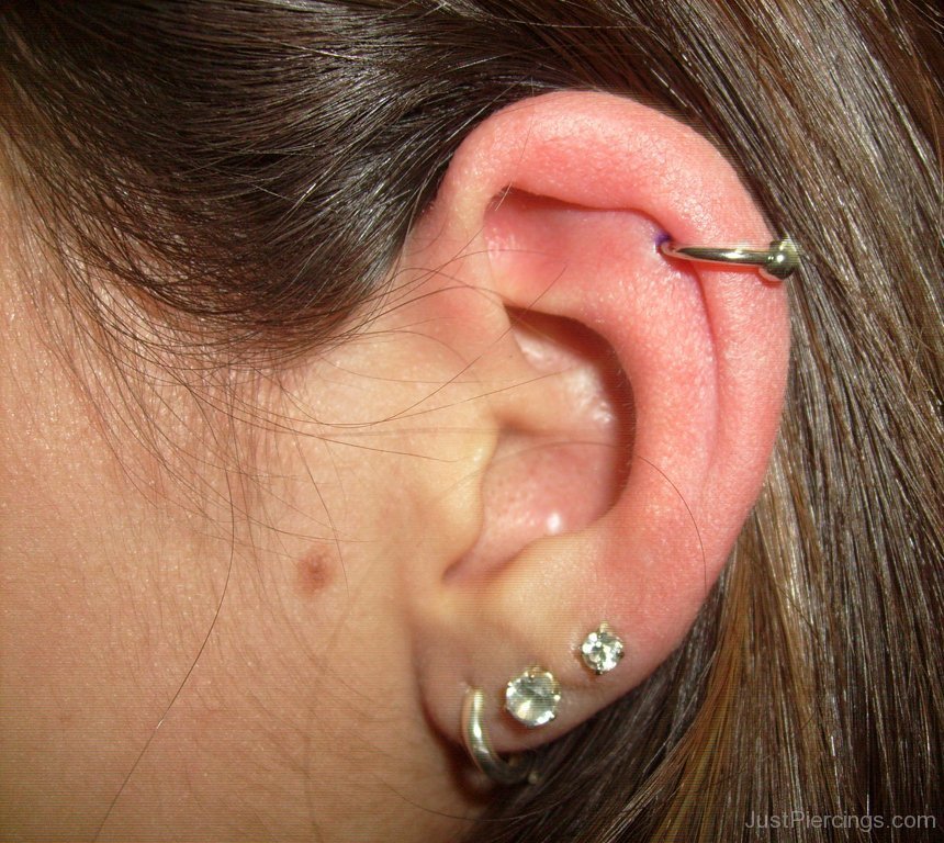 Lobe And Helix Piercing With Golden Ring.