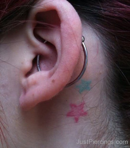 Flower Tattoos And Large Orbital Piercing On Girl Left Ear