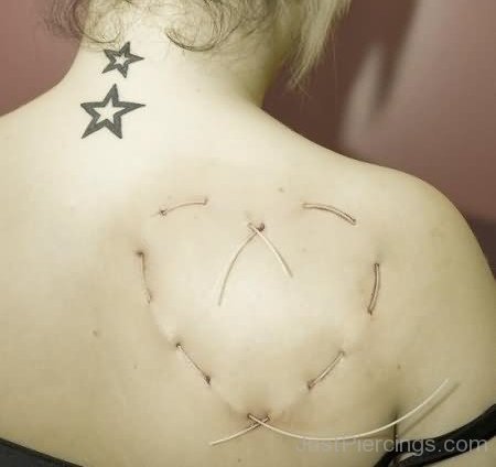 Star Tattoos And Surface Weave Piercing On Right Back Shoulder