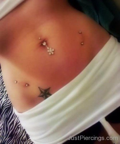 Hip Piercing And Nautical Star Tattoo