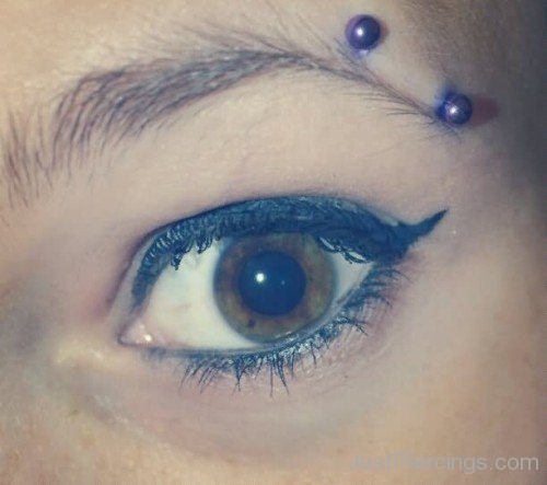 Horizontal Eyebrow Piercing With Blue Barbell