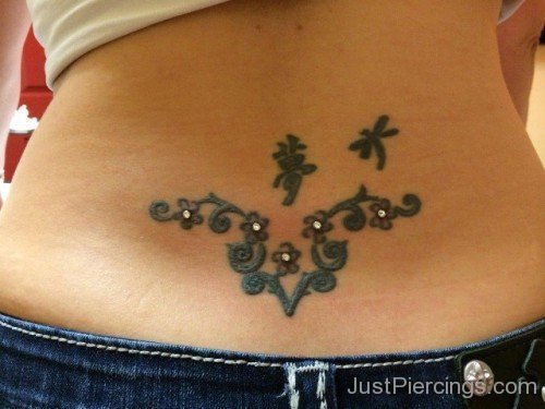 Lower Back Piercing With Tattoo