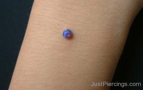 Piercing With Blue Labret Stud On Arm