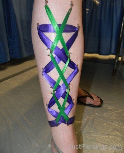 Purple And Green Corset Piercing On Leg