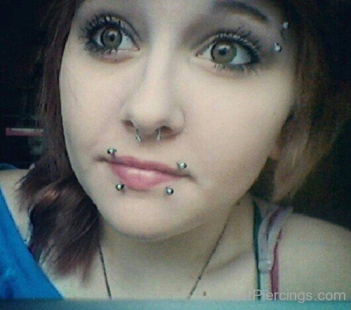 Girl With Eyebrow Septum and Canine Bites Piercing With Green Barbells-JP1429